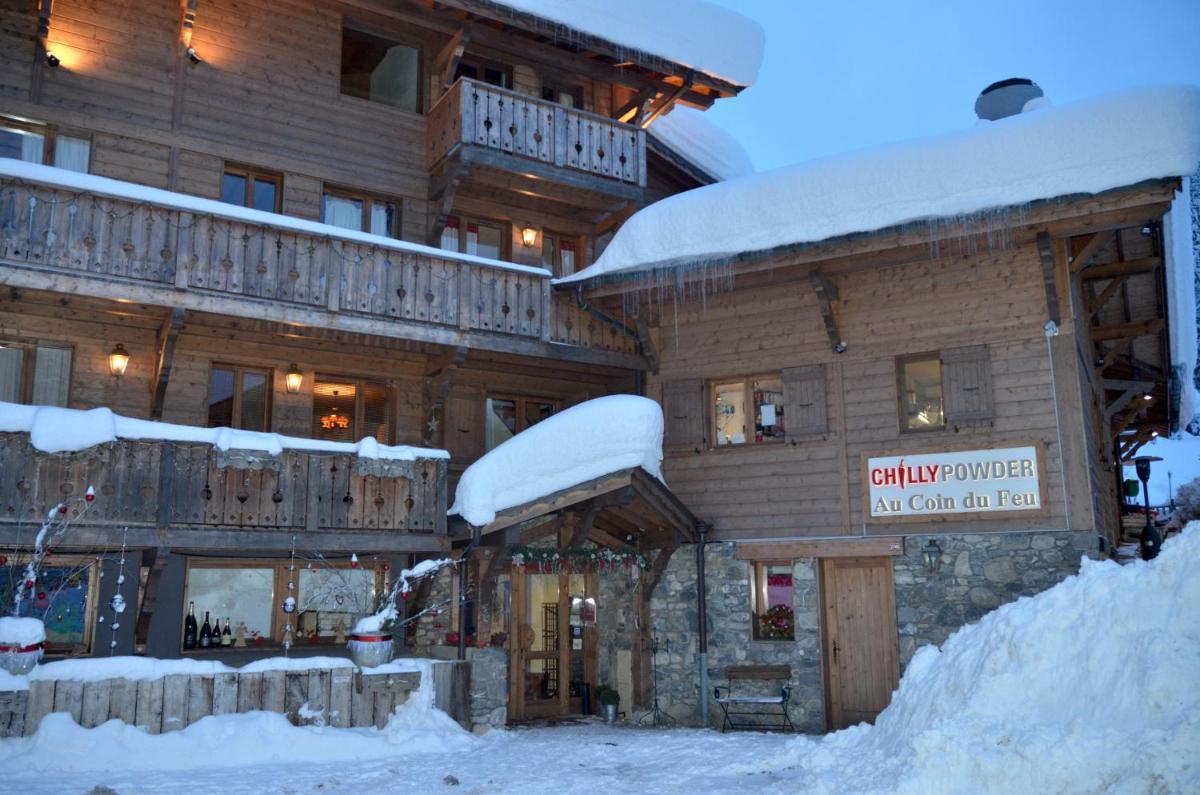 d'un grand bâtiment en bois recouvert de neige. dans l'établissement Hôtel et Chalet Au Coin Du Feu Chilly Powder, à Morzine