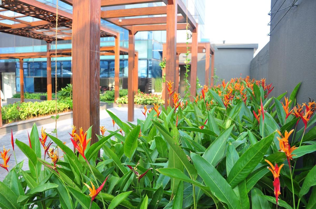 a garden with orange flowers in front of a building at The Raviz Calicut in Kozhikode
