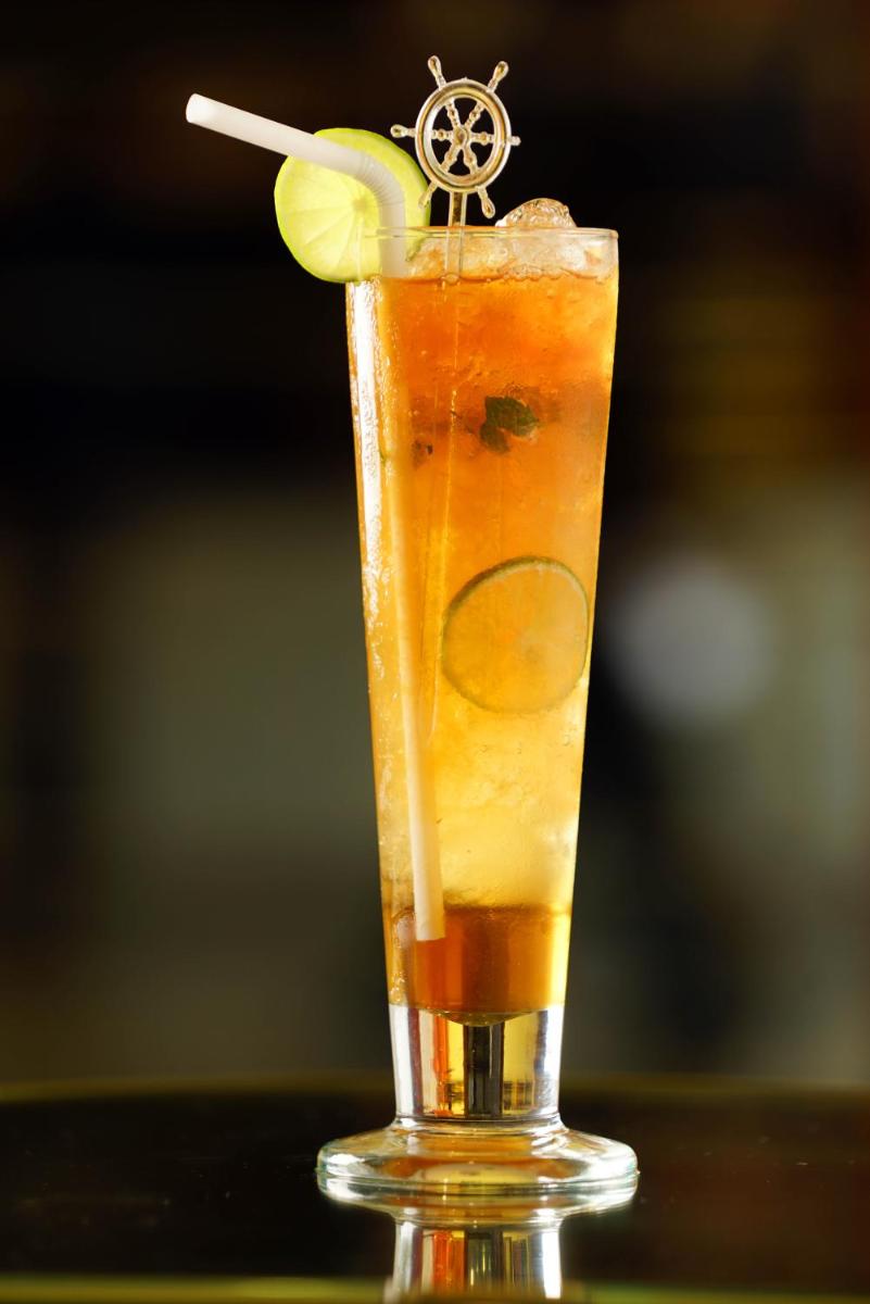 a drink with a slice of lime and a stick at The Raviz Calicut in Kozhikode
