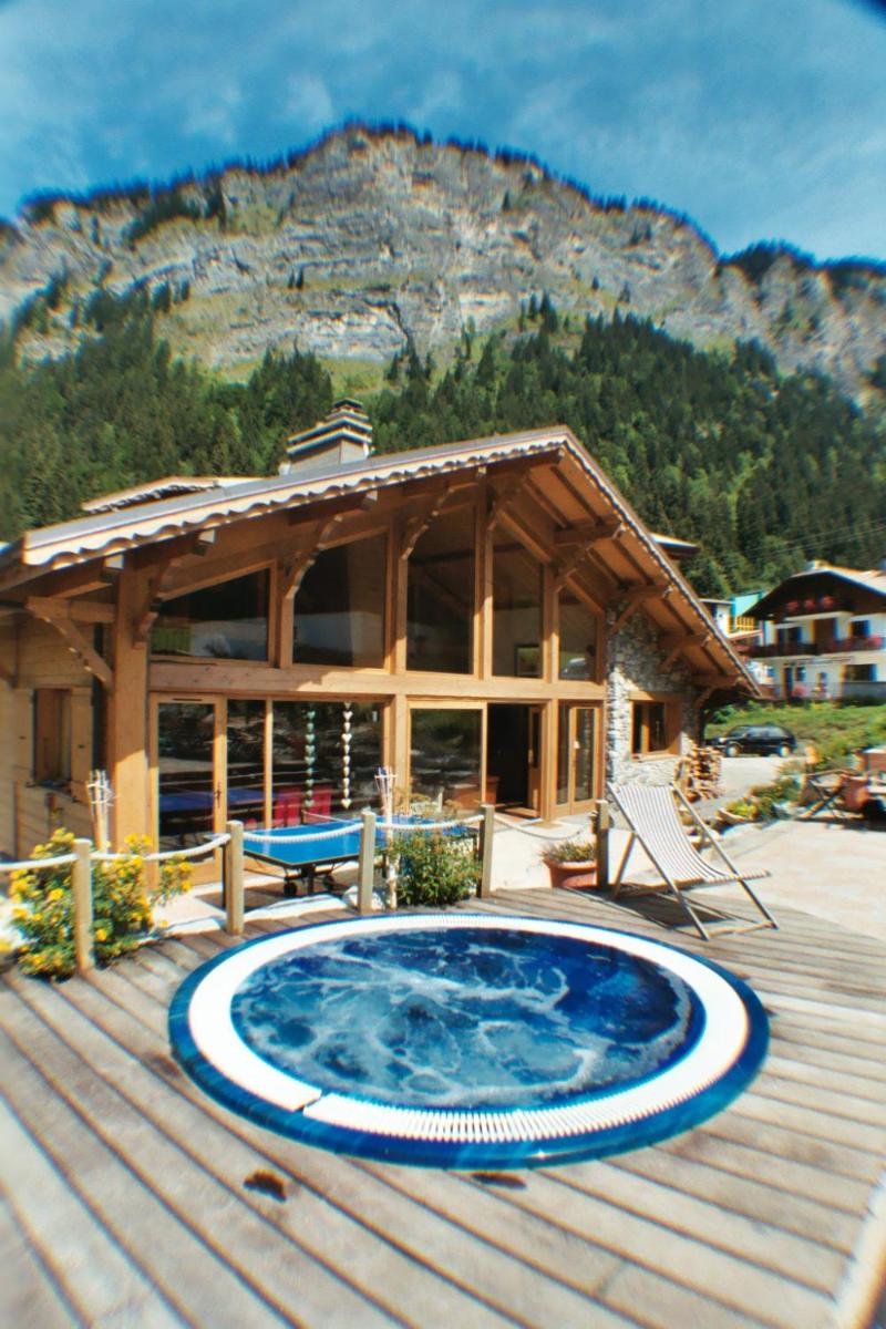 une maison avec un bain à remous sur une terrasse en bois dans l'établissement Hôtel et Chalet Au Coin Du Feu Chilly Powder, à Morzine 34 autres photos