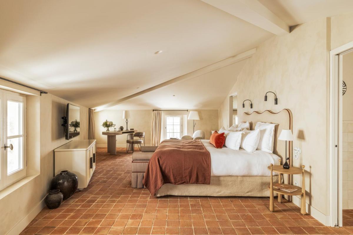 une chambre avec un grand lit dans une pièce dans l'établissement La Maison d'Uzès Relais & Châteaux, à Uzès