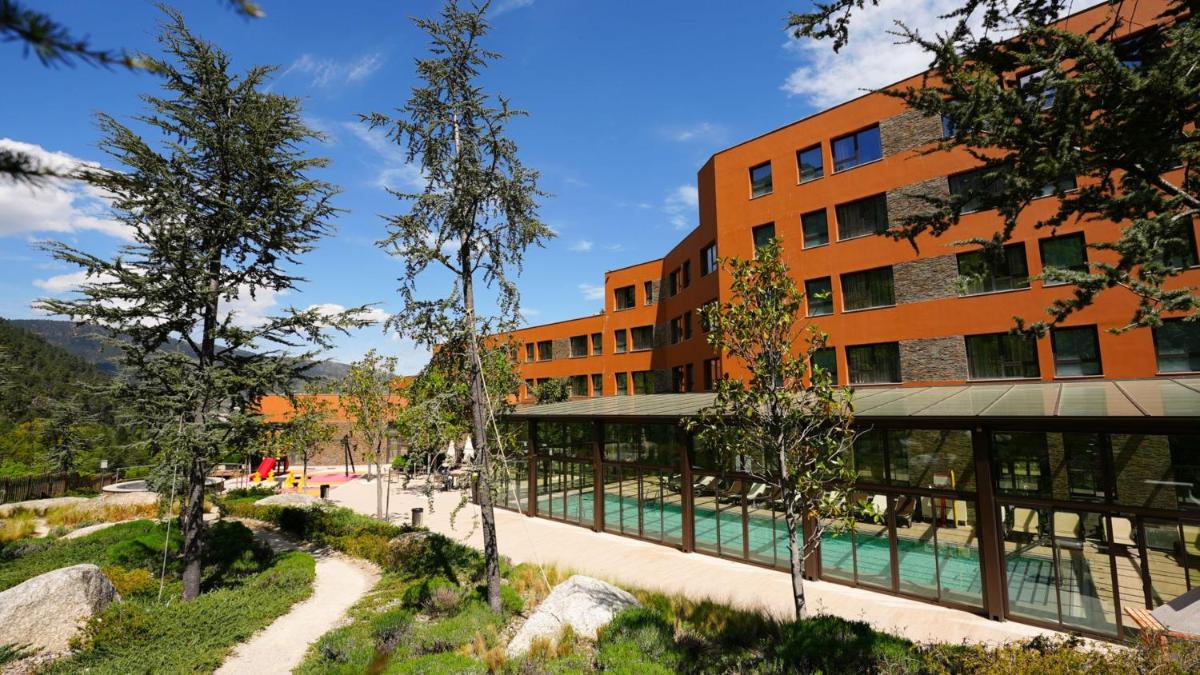 um prédio laranja com uma piscina em frente. em Vila Galé Collection Serra da Estrela em Manteigas