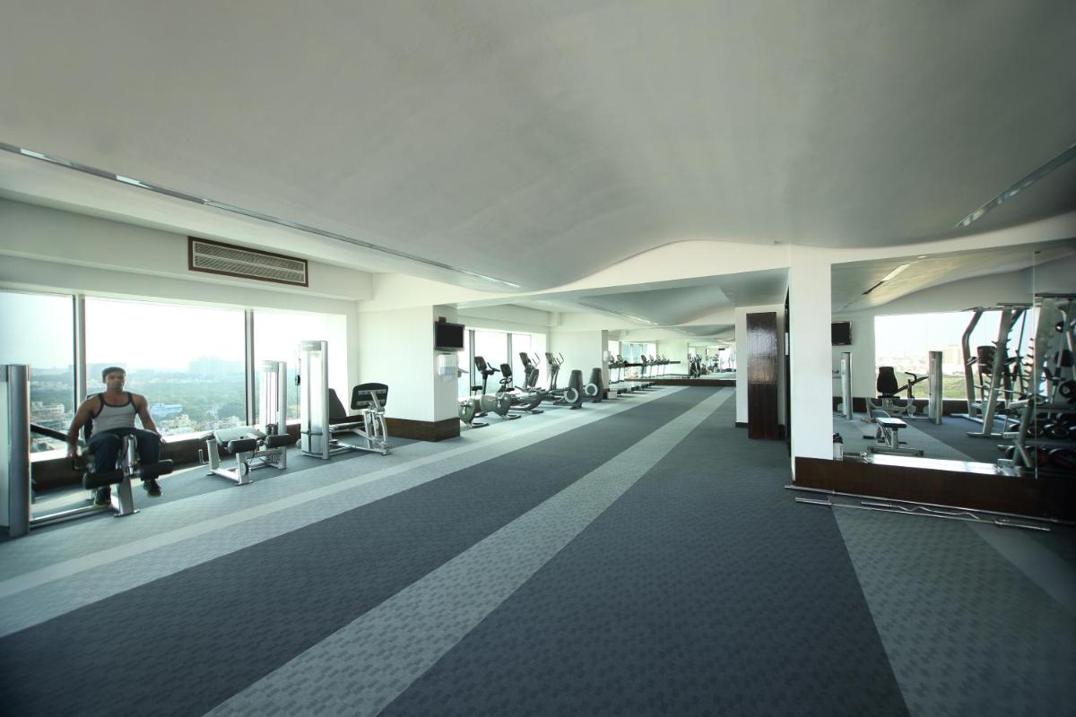 a large room with people exercising in a gym at Gokulam Grand Hotel & Spa Bangalore in Bengaluru a large room with people exercising in a gym at Gokulam Grand Hotel & Spa Bangalore in Bengaluru