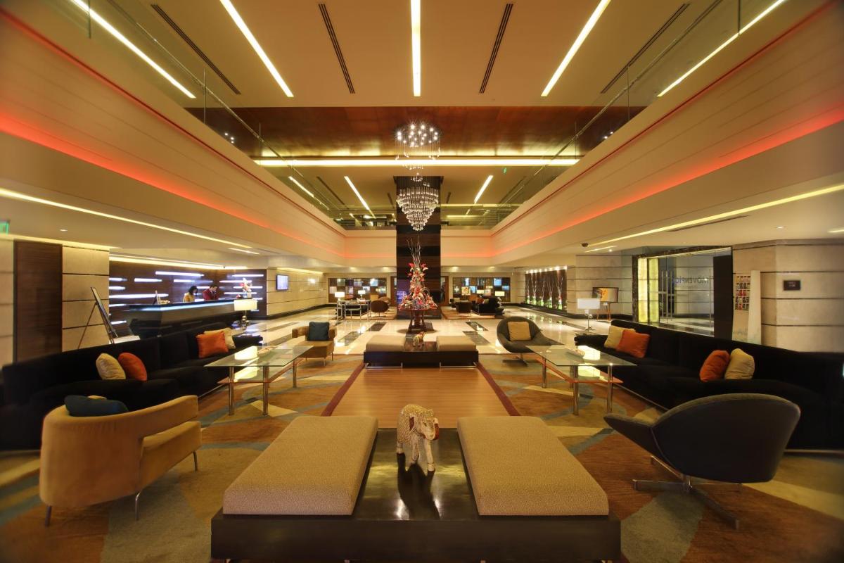 a lobby with couches and tables in a building at Gokulam Grand Hotel & Spa Bangalore in Bengaluru a lobby with couches and tables in a building at Gokulam Grand Hotel & Spa Bangalore in Bengaluru