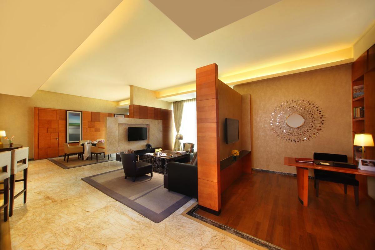 a living room with a couch and a dining room at Gokulam Grand Hotel & Spa Bangalore in Bengaluru a living room with a couch and a dining room at Gokulam Grand Hotel & Spa Bangalore in Bengaluru