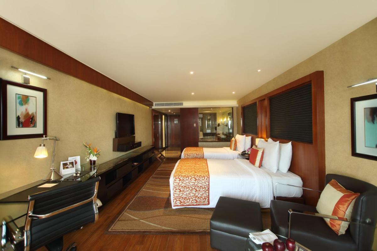 a hotel room with a bed and a television at Gokulam Grand Hotel & Spa Bangalore in Bengaluru a hotel room with a bed and a television at Gokulam Grand Hotel & Spa Bangalore in Bengaluru