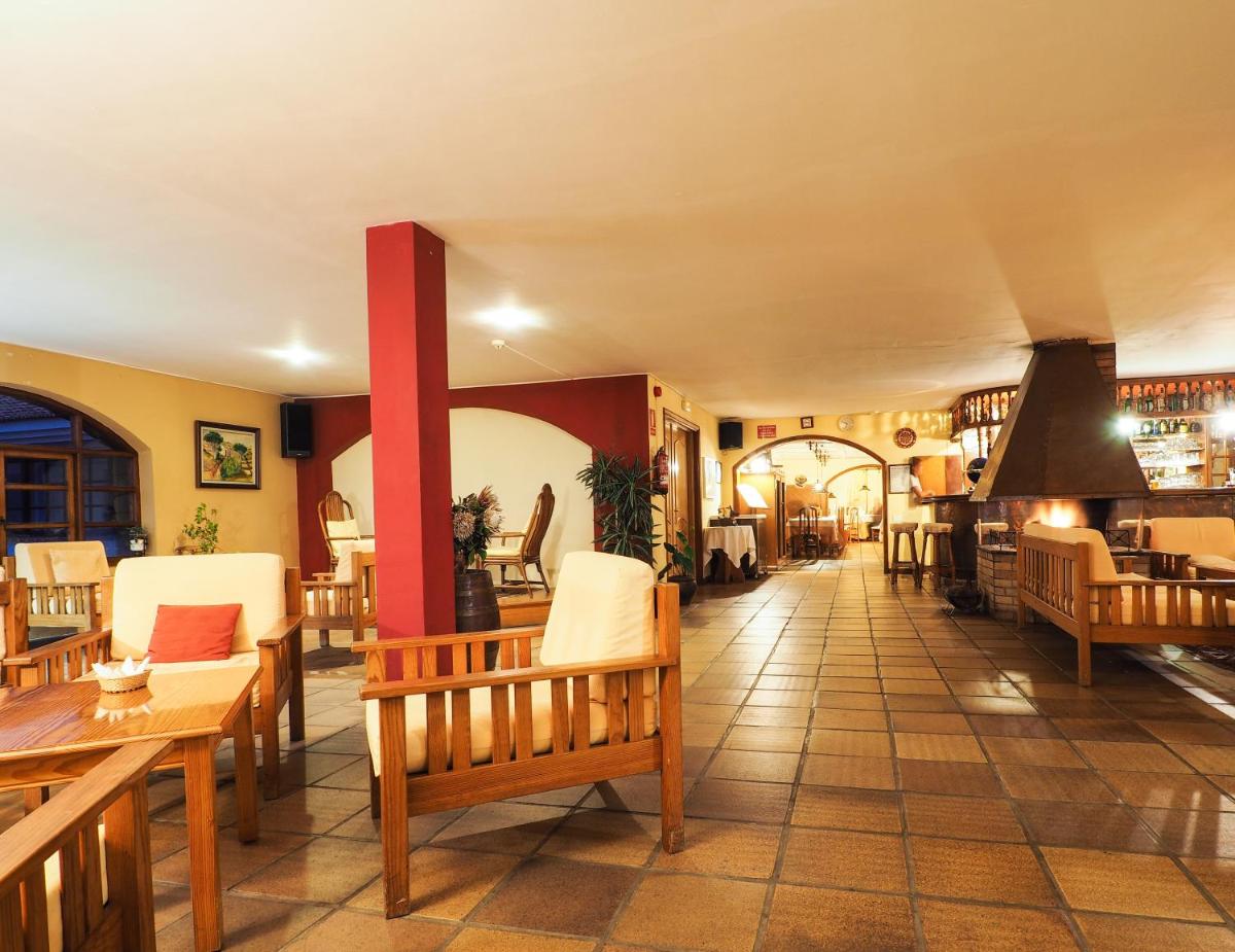 un restaurante con mesas y sillas de madera y una habitación en Hotel La Palma Romántica, en Barlovento