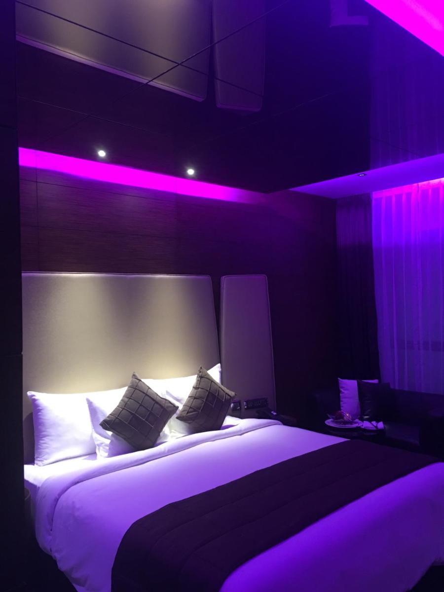 a bedroom with a large bed with purple lighting at Radisson Blu Atria Bengaluru in Bengaluru a bedroom with a large bed with purple lighting at Radisson Blu Atria Bengaluru in Bengaluru