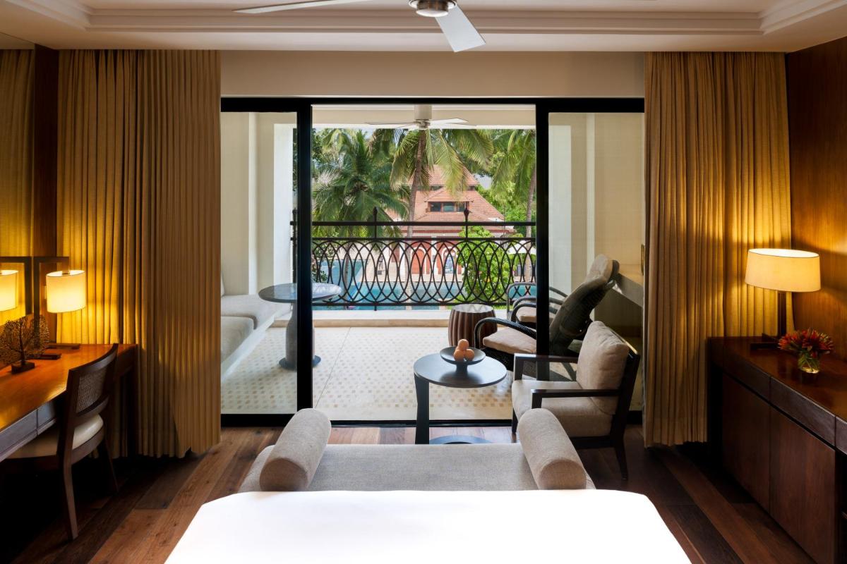 a hotel room with a bed and a balcony at Grand Hyatt Goa in Panaji a hotel room with a bed and a balcony at Grand Hyatt Goa in Panaji