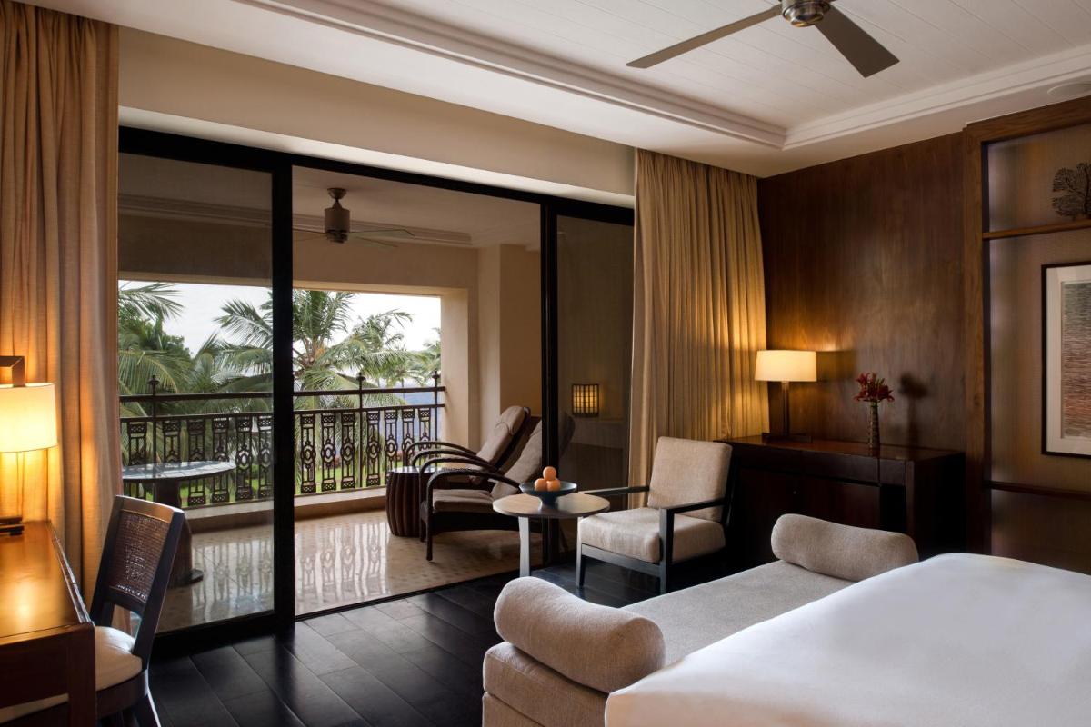 a hotel room with a bed and a balcony at Grand Hyatt Goa in Panaji a hotel room with a bed and a balcony at Grand Hyatt Goa in Panaji