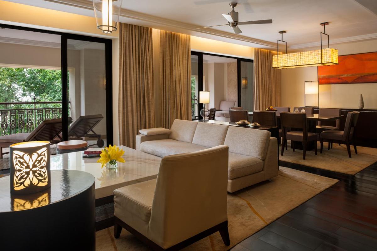 a living room with a couch and a dining room at Grand Hyatt Goa in Panaji a living room with a couch and a dining room at Grand Hyatt Goa in Panaji