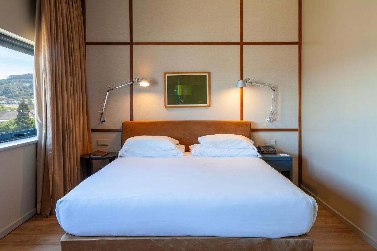 Uma cama ou camas num quarto em Hotel de Guimaraes Business & SPA
