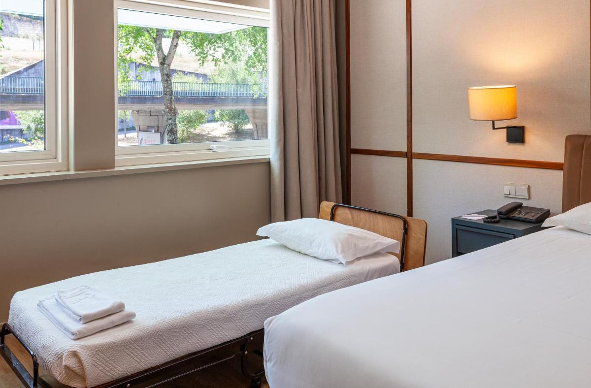 Uma cama ou camas num quarto em Hotel de Guimaraes Business & SPA