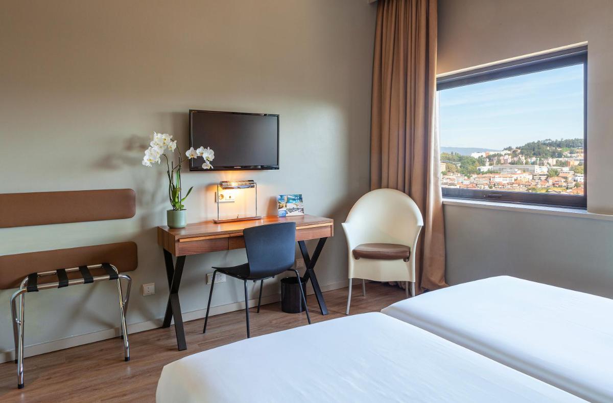 Uma cama ou camas num quarto em Hotel de Guimaraes Business & SPA