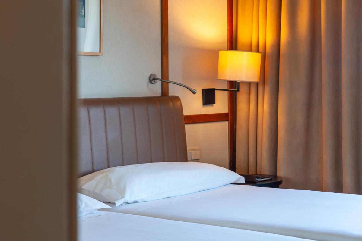Uma cama ou camas num quarto em Hotel de Guimaraes Business & SPA