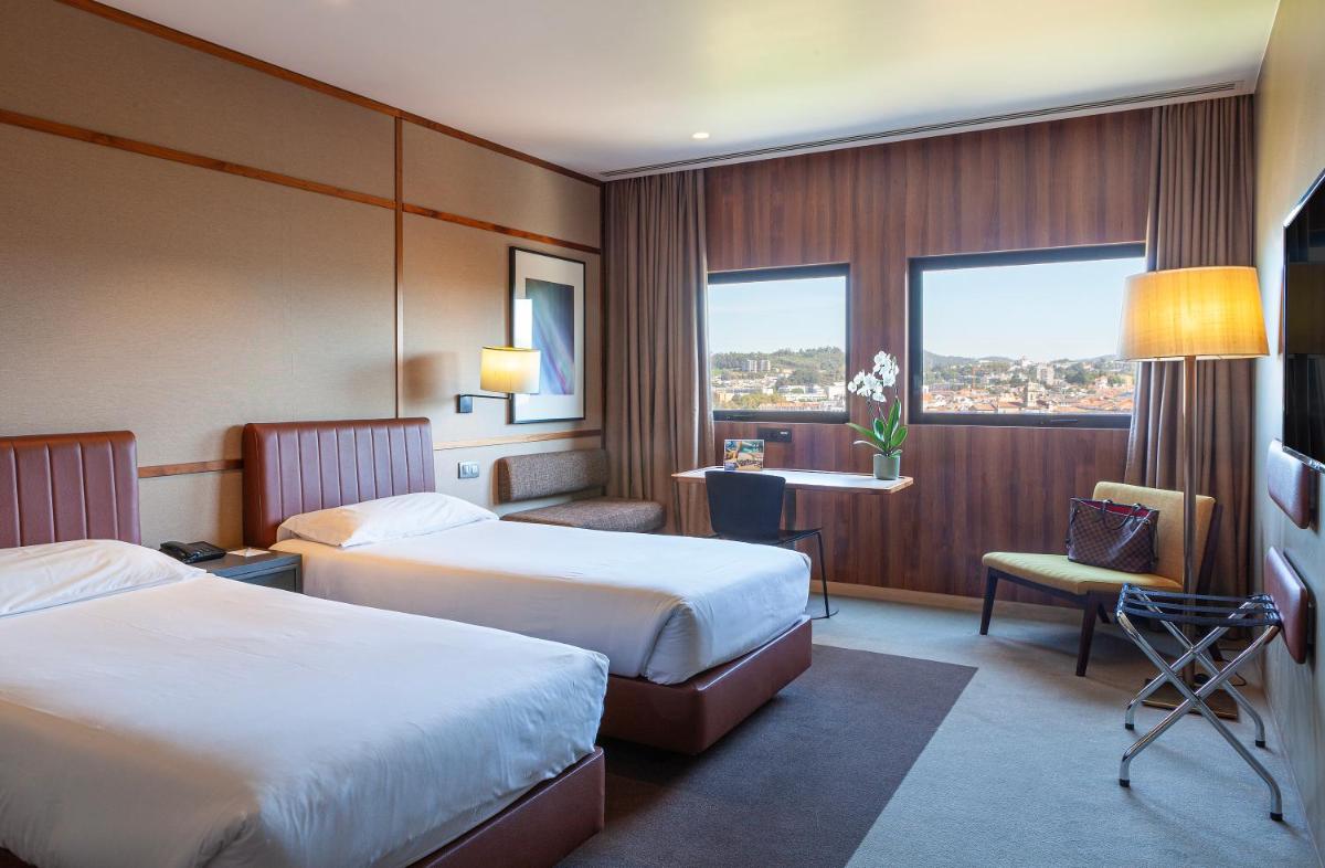 Uma cama ou camas num quarto em Hotel de Guimaraes Business & SPA