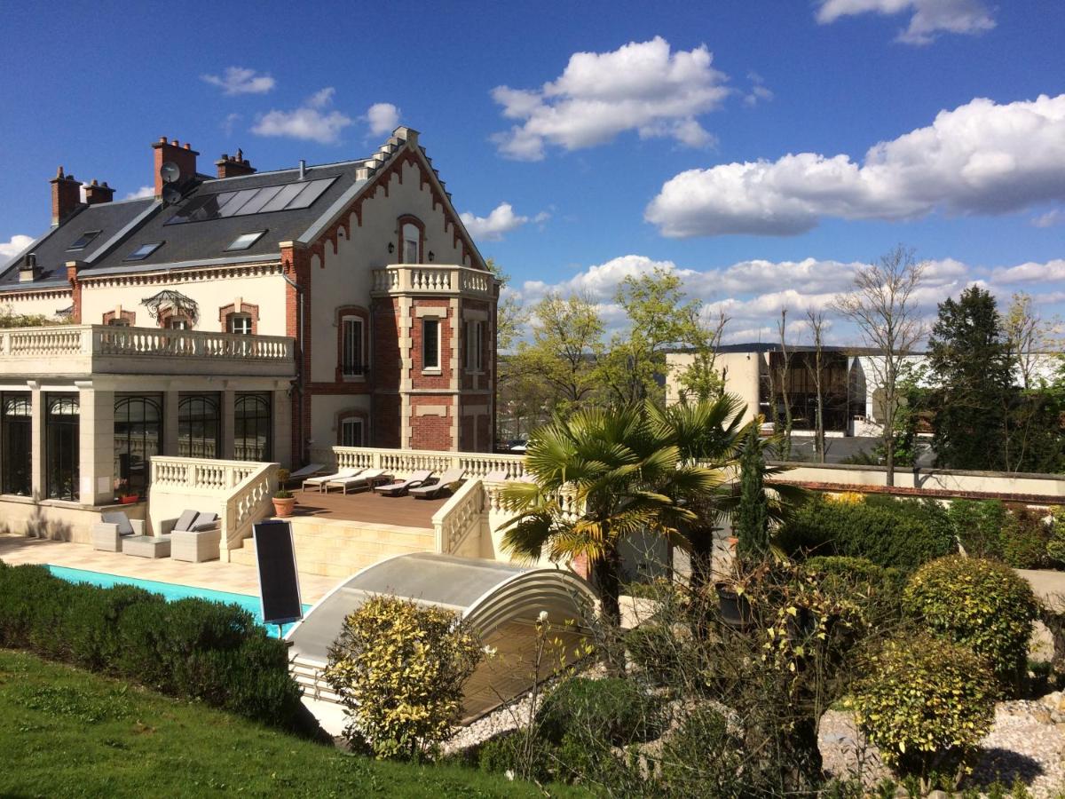 une grande maison avec une piscine devant dans l'établissement Hôtel La Villa Eugene, à Épernay