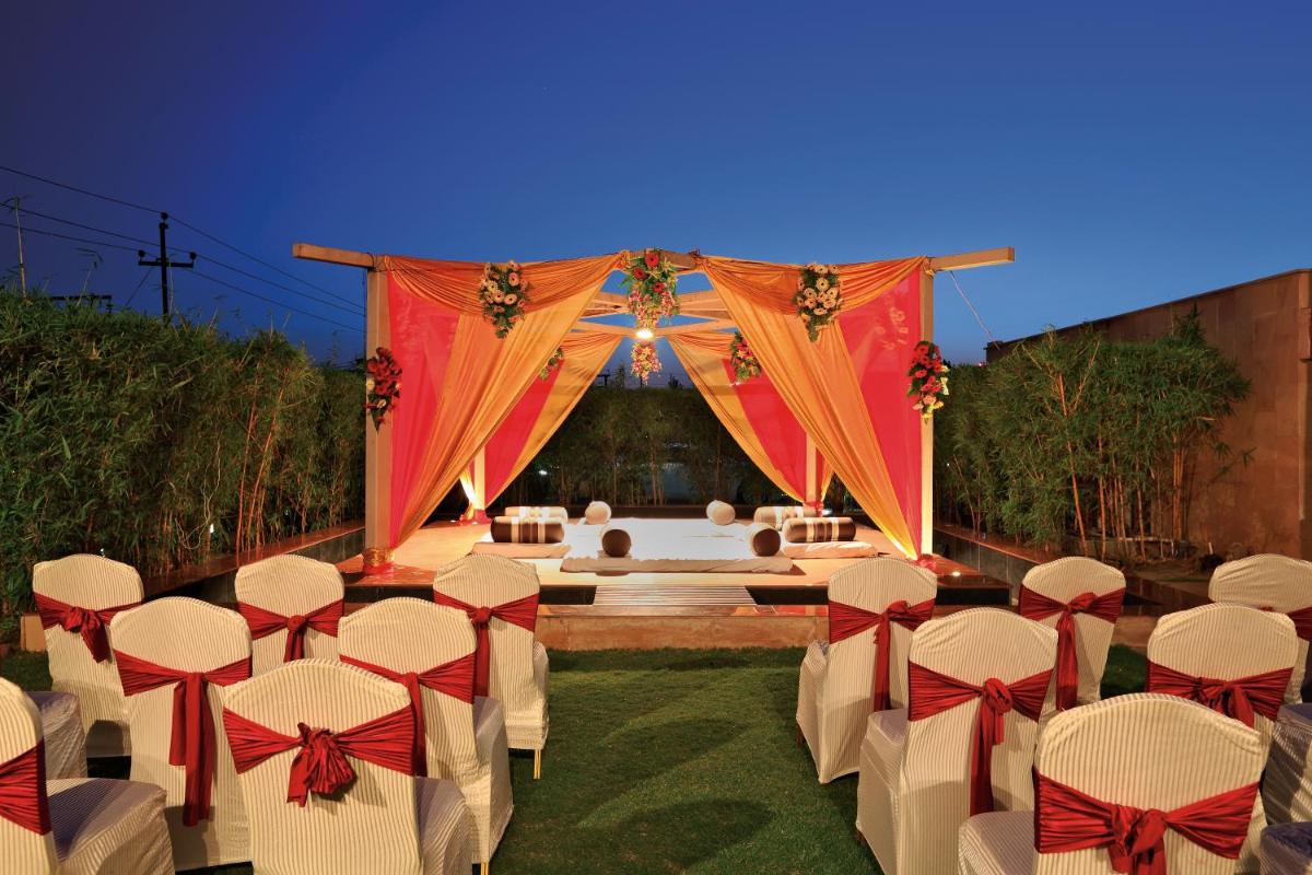 a set up for a wedding with white chairs and red bows at Yashail Hotel Haridwar in Haridwār