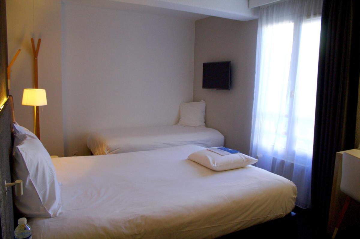 Un ou plusieurs lits dans un hébergement de l'établissement Kyriad Hotel Brest