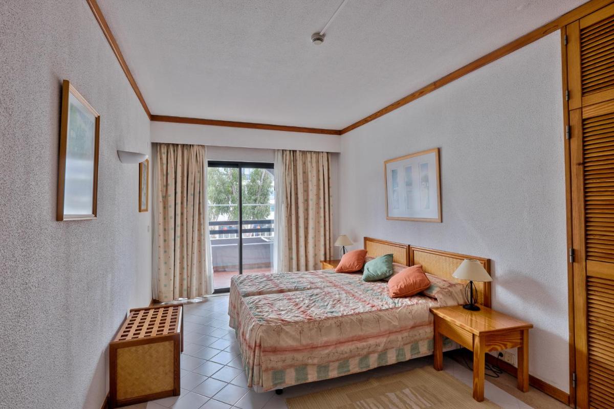 Uma cama ou camas num quarto em Muthu Oura Praia Hotel