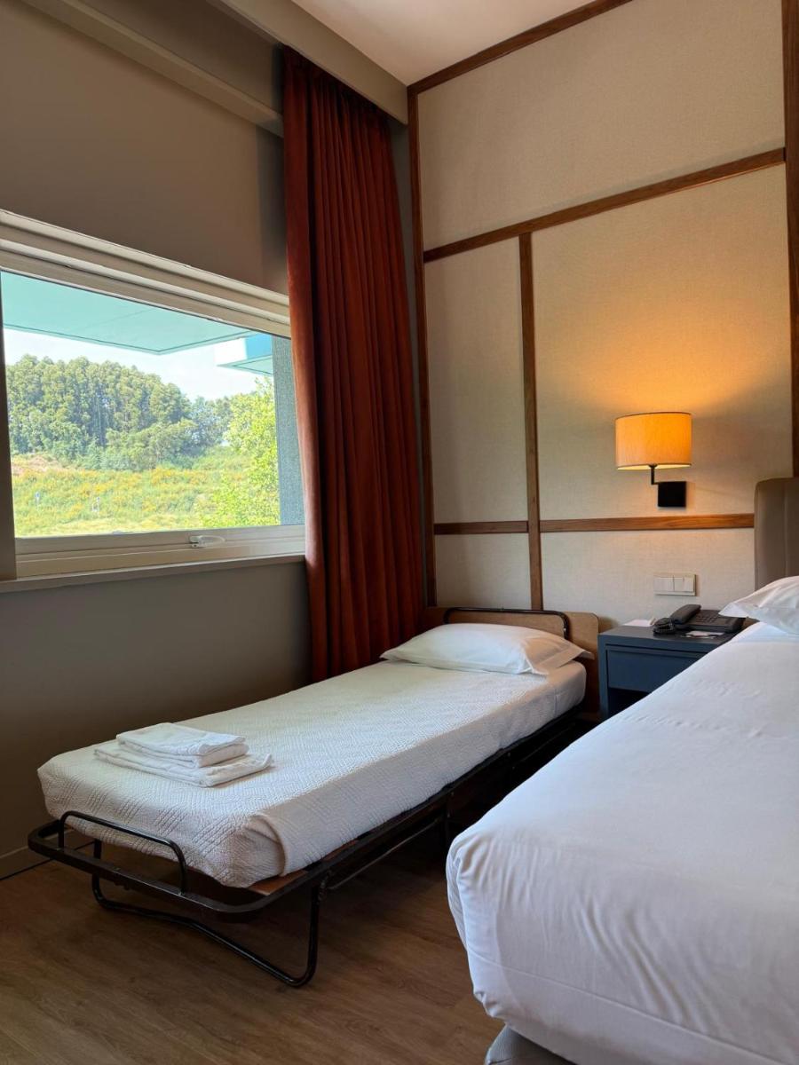 Uma cama ou camas num quarto em Hotel de Guimaraes Business & SPA
