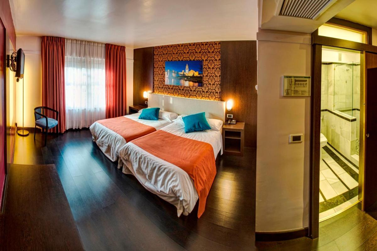 Una habitación de hotel con una cama grande con almohadas azules. en Hotel Spa Rio Ucero, en El Burgo de Osma 59 fotos más