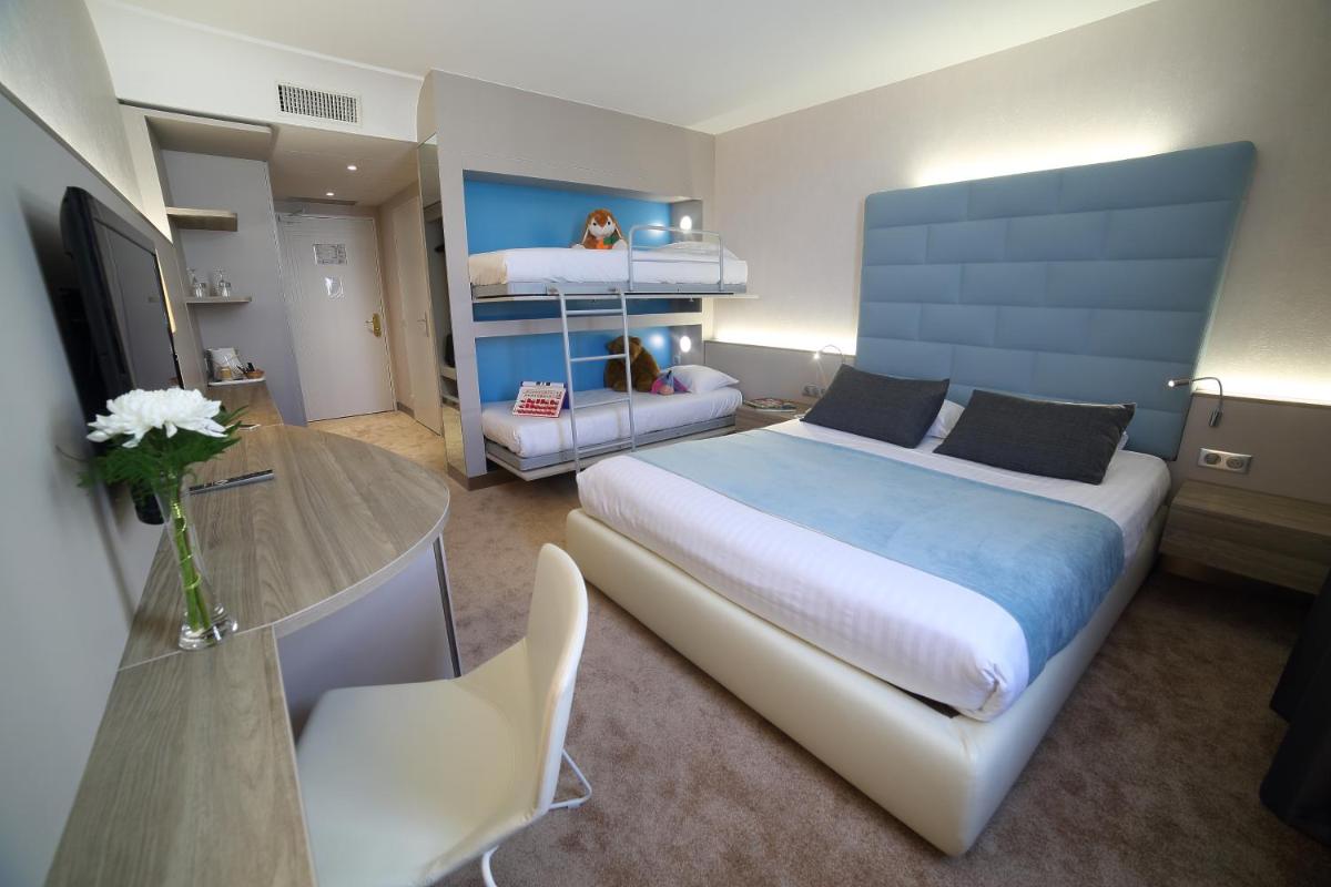 une chambre avec un grand lit et une table dans l'établissement Hotel Plaza - site du Futuroscope, à Chasseneuil-du-Poitou 63 autres photos