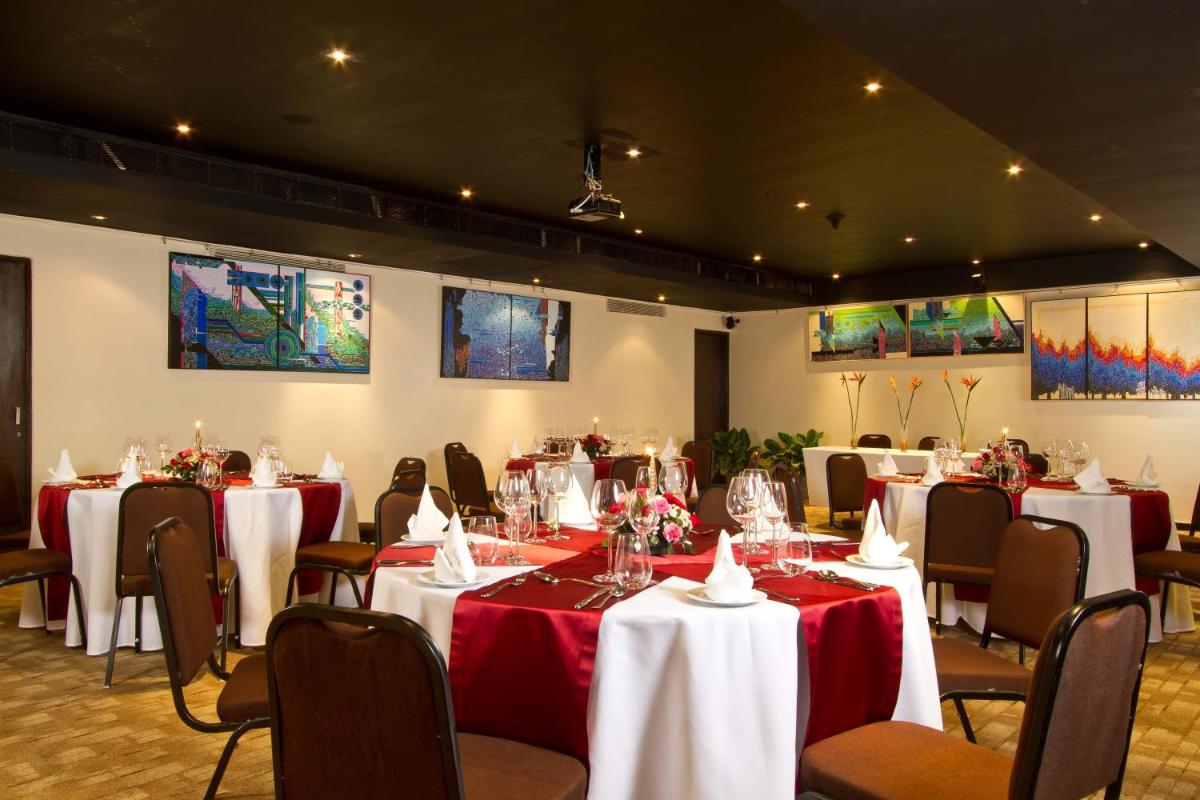 a room with tables and chairs with red and white table cloth at Svenska Design Hotel in Mumbai +40 photos
