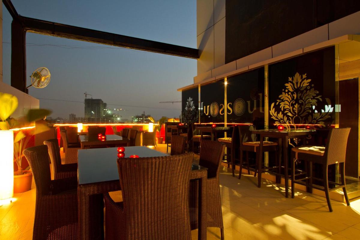 a restaurant with tables and chairs on a balcony at Svenska Design Hotel in Mumbai