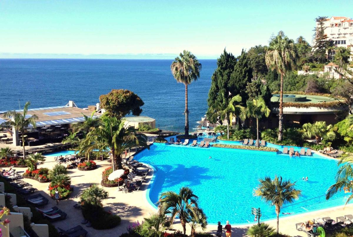 uma grande piscina com o oceano ao fundo em Pestana Madeira Beach Club no Funchal