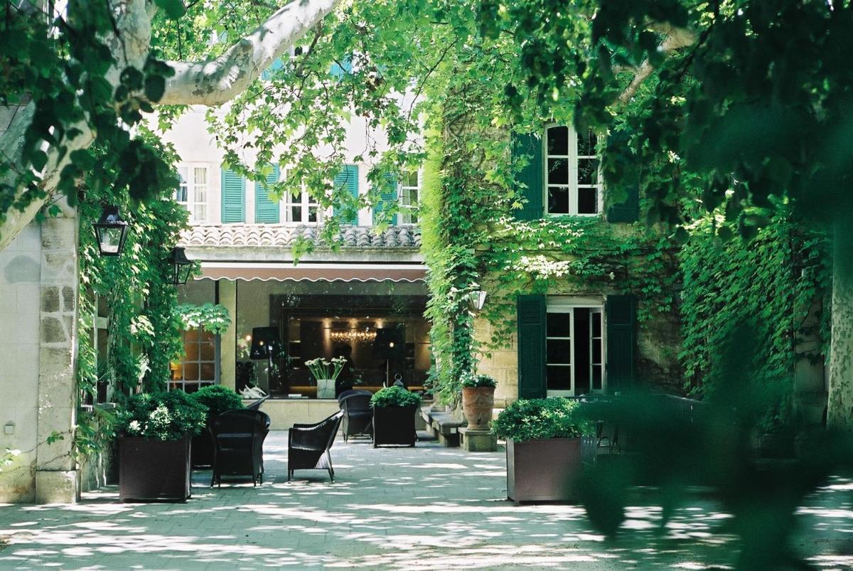 - une cour avec des chaises et du lierre dans un bâtiment dans l'établissement Le Prieure, à Villeneuve-lès-Avignon