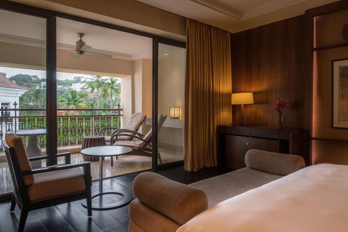 a hotel room with a bed and a balcony at Grand Hyatt Goa in Panaji a hotel room with a bed and a balcony at Grand Hyatt Goa in Panaji