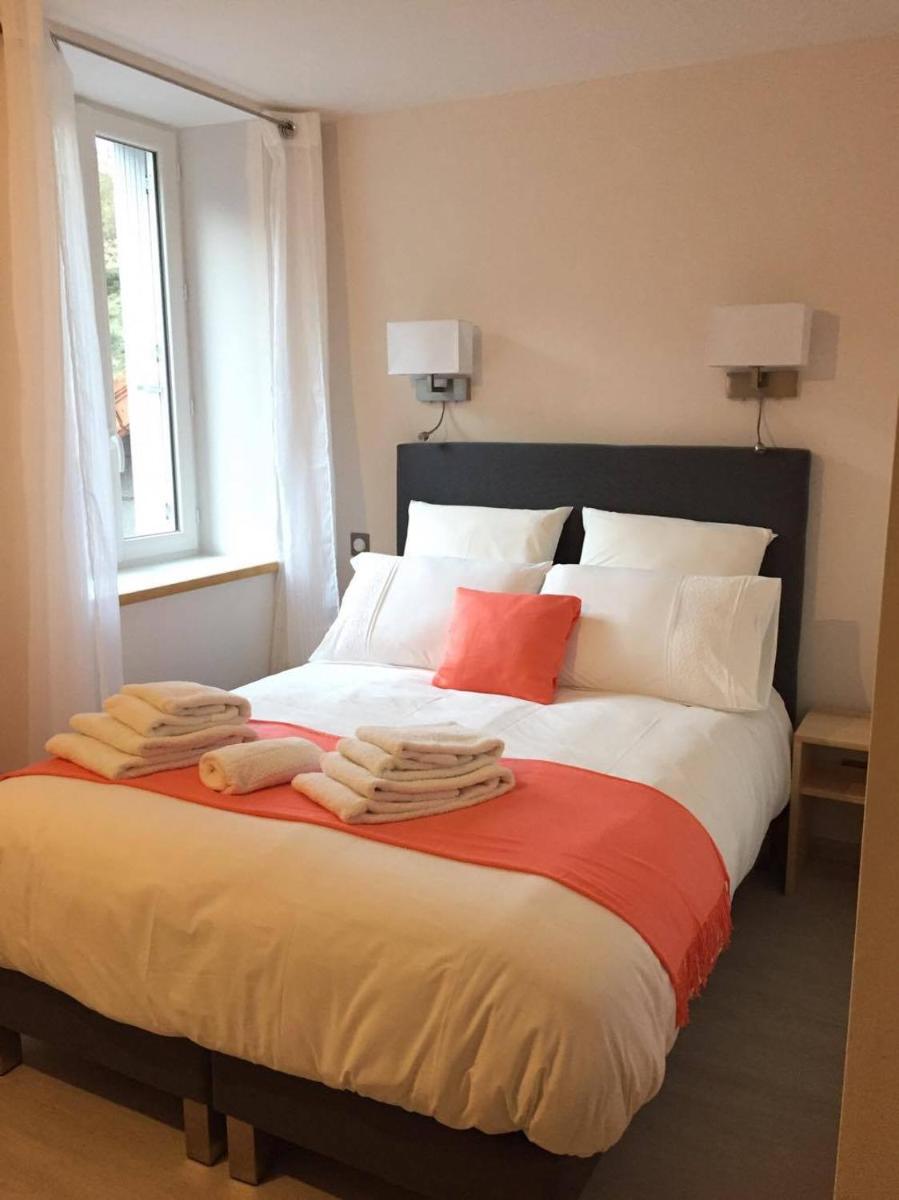 une chambre avec un grand lit avec des serviettes dessus dans l'établissement Hôtel du Bout du Monde, à Saint-Flour