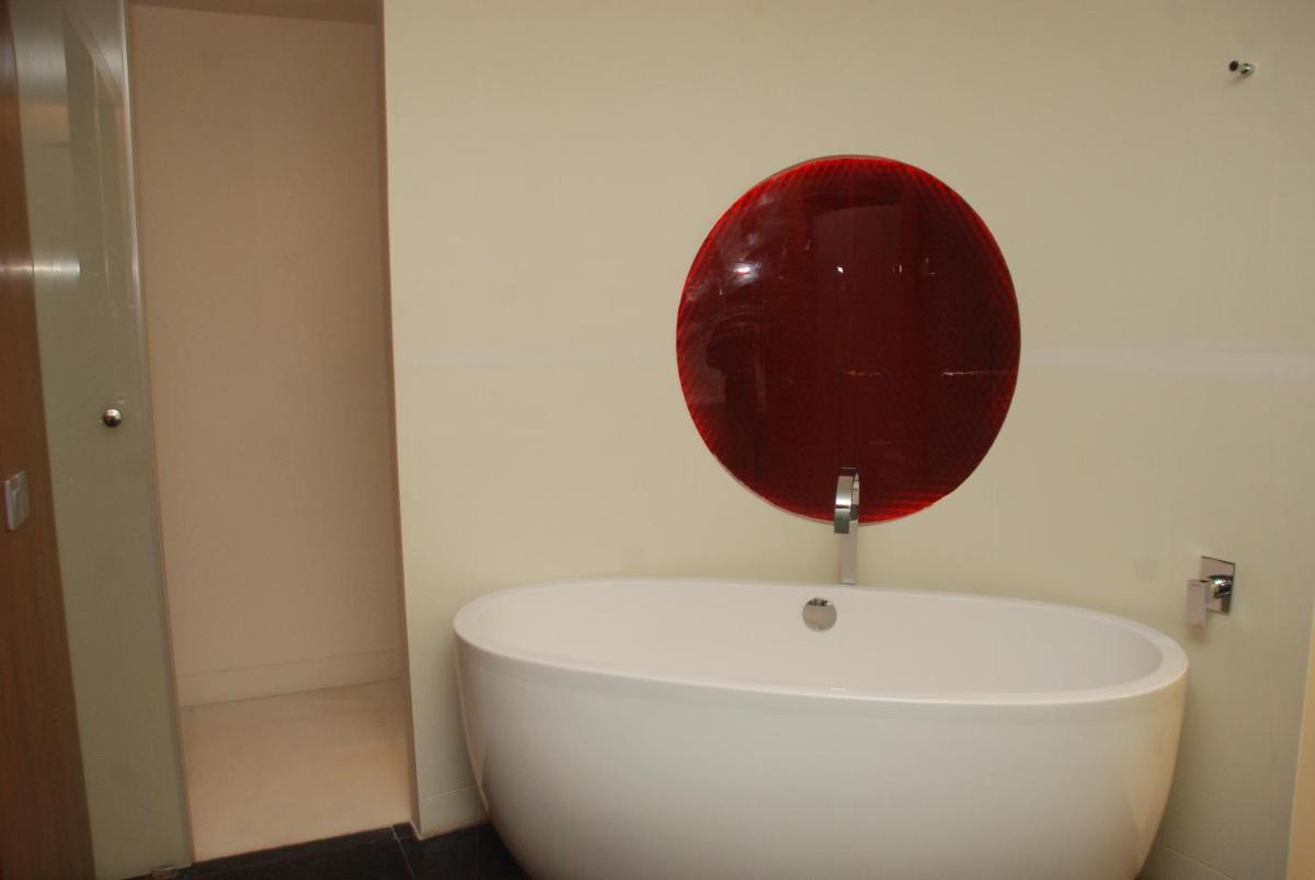 a white bathroom with a red circle on the wall at The Park Hyderabad, Banjara Hills near Hussain Sagar Lake in Hyderabad a white bathroom with a red circle on the wall at The Park Hyderabad, Banjara Hills near Hussain Sagar Lake in Hyderabad