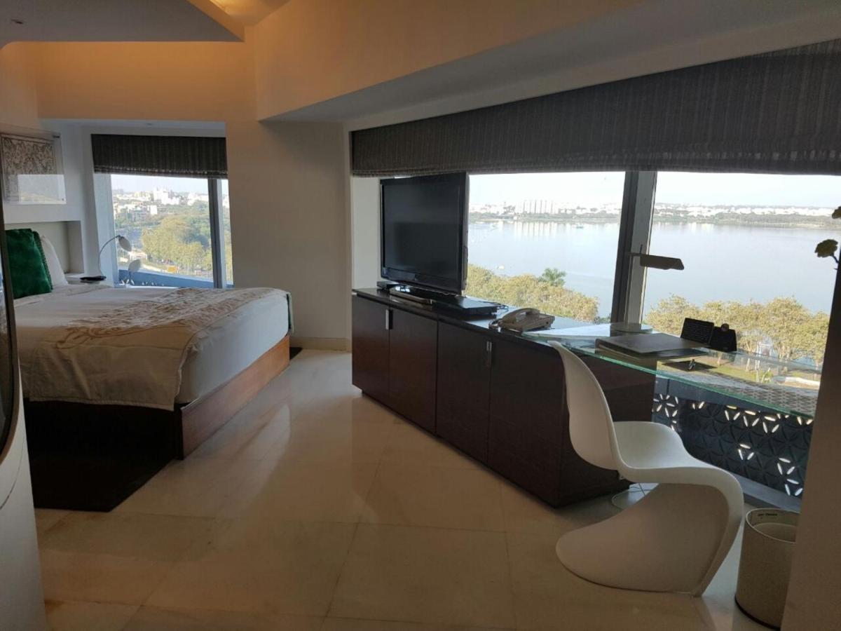a bedroom with a bed and a desk with a television at The Park Hyderabad, Banjara Hills near Hussain Sagar Lake in Hyderabad a bedroom with a bed and a desk with a television at The Park Hyderabad, Banjara Hills near Hussain Sagar Lake in Hyderabad