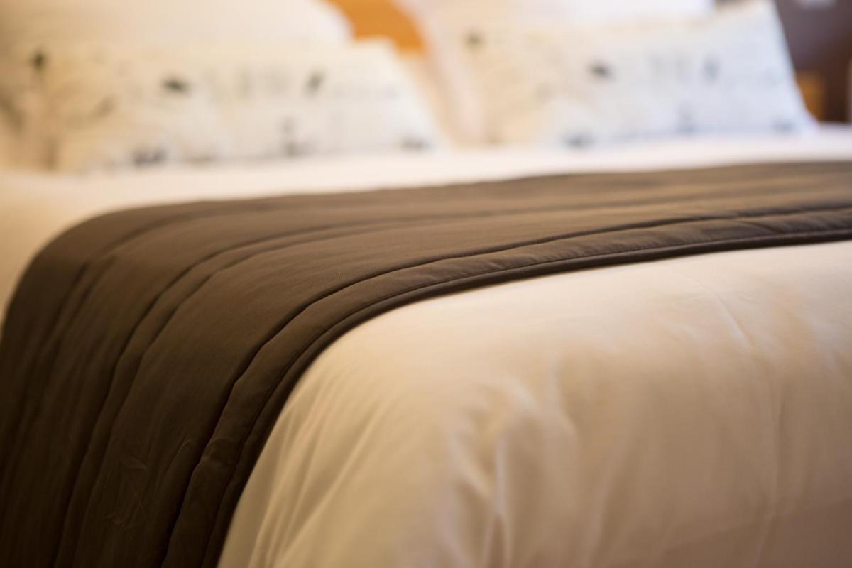 Un ou plusieurs lits dans un hébergement de l'établissement Logis hôtel restaurant Auberge de l'Espinouse