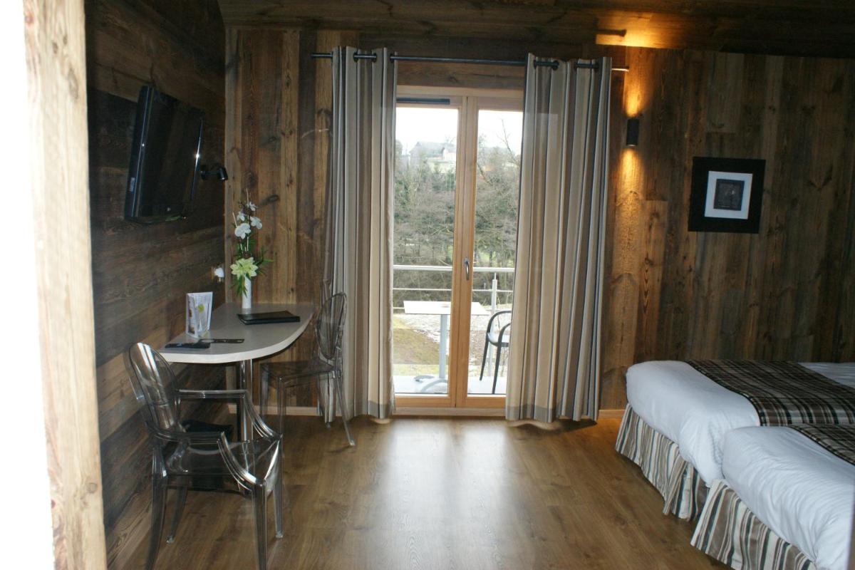 une chambre avec un lit, une table et une fenêtre dans l'établissement Hotel Blanc, à Marigny-Saint-Marcel