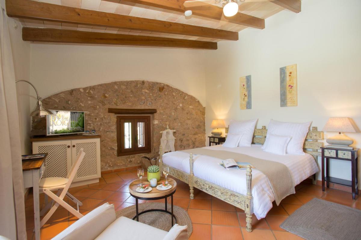 Un dormitorio con una cama grande y una sala de estar. en Casa Font i Roig, en Maria de la Salut 138 fotos más