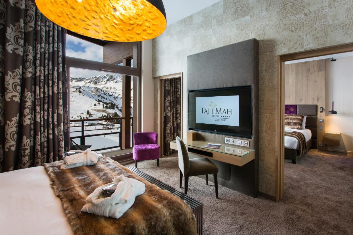 une chambre d'hôtel avec un lit, un bureau et une télévision dans l'établissement Hôtel Taj-I Mah by Les Etincelles, à Arc 2000