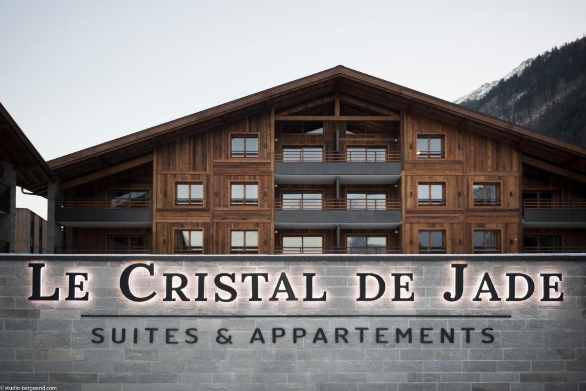 un bâtiment avec une enseigne devant lui dans l'établissement MGM Hôtels & Résidences - Résidence Le Cristal de Jade, à Chamonix-Mont-Blanc