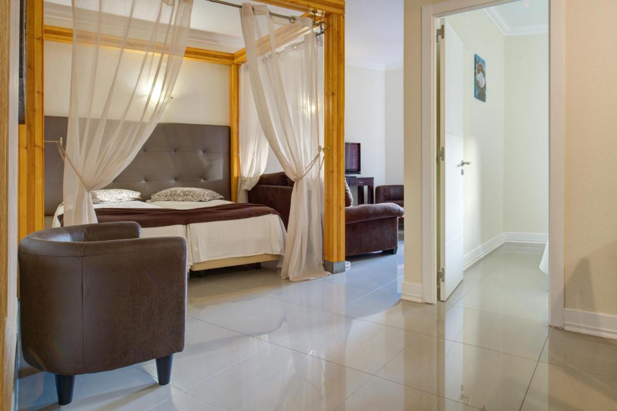 um quarto com uma cama e uma cadeira em Choromar Apartments em Albufeira mais 103 fotografias