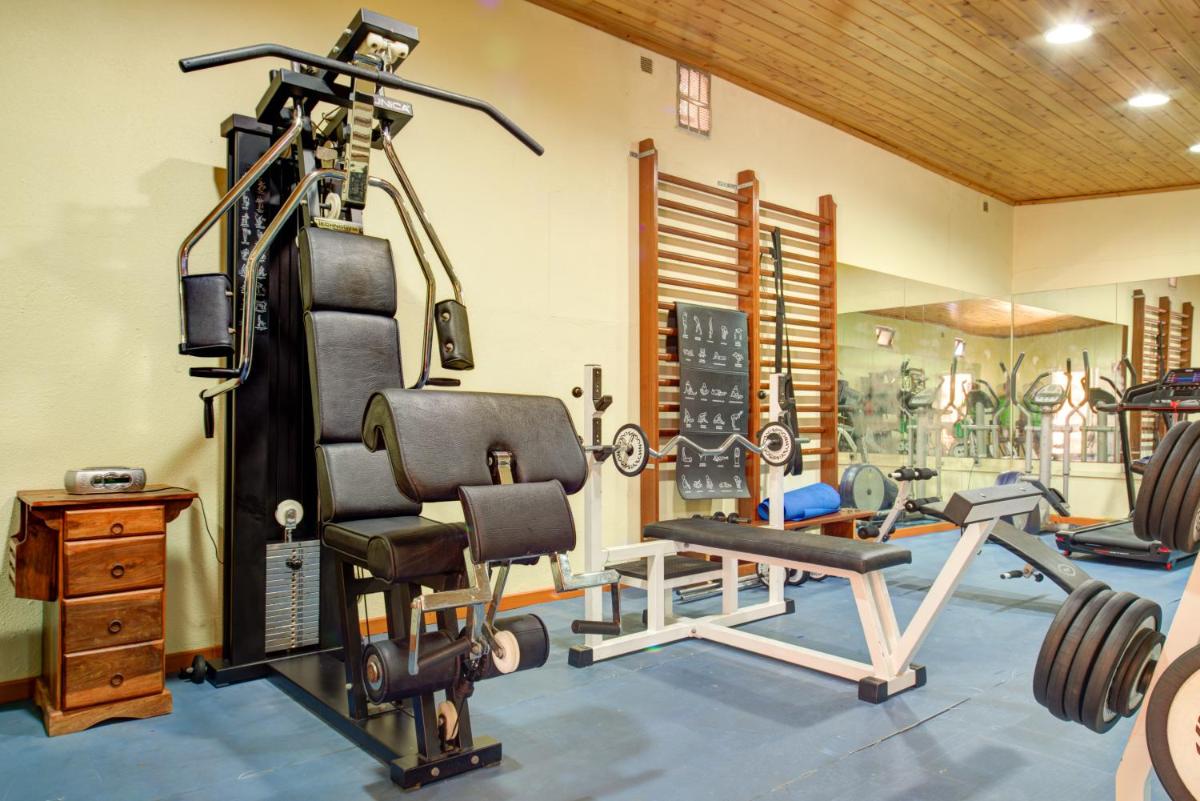 uma sala de fitness com um ginásio com um banco e pesos em Choromar Apartments em Albufeira