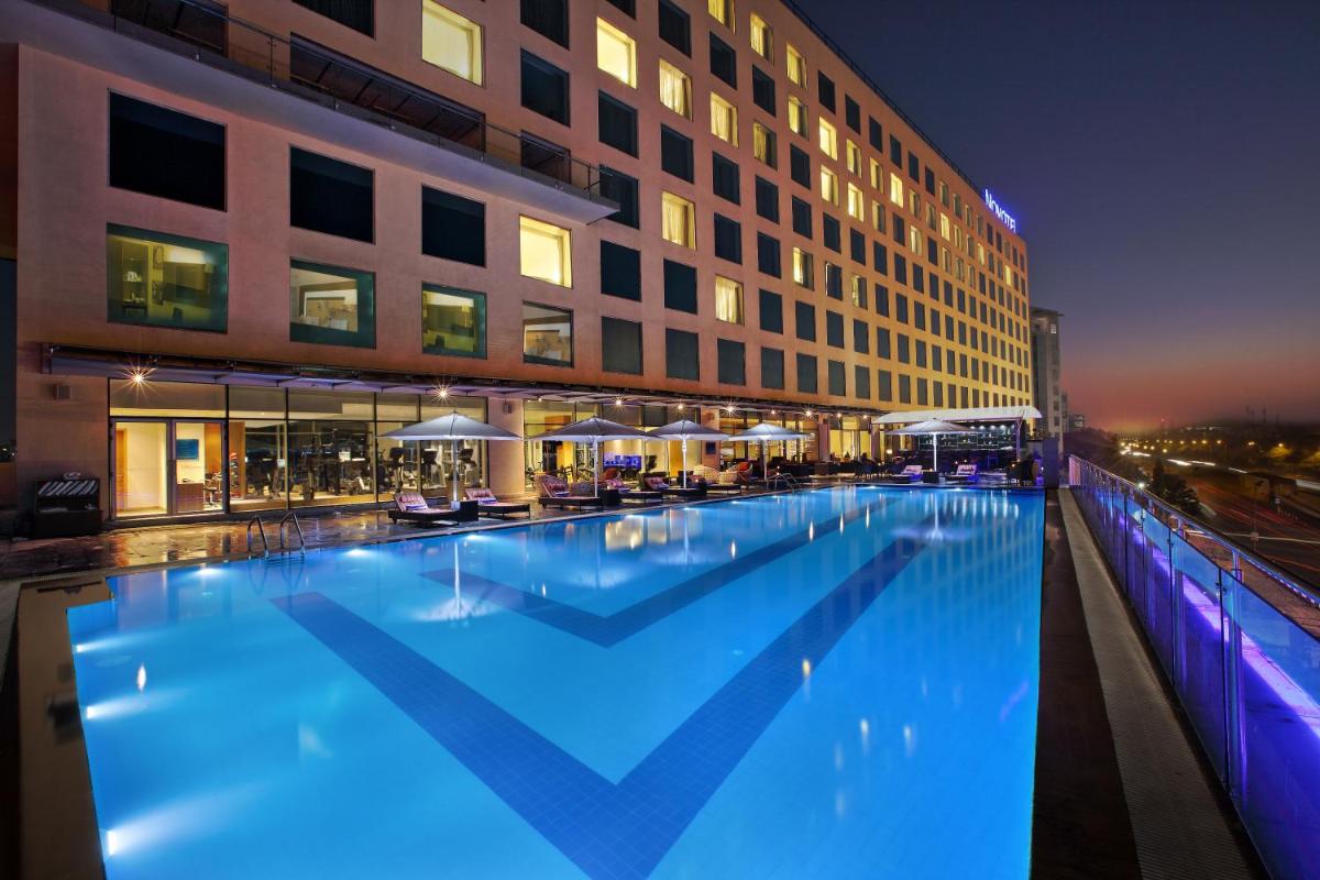 a large swimming pool in front of a building at Novotel Pune Viman Nagar Road in Pune