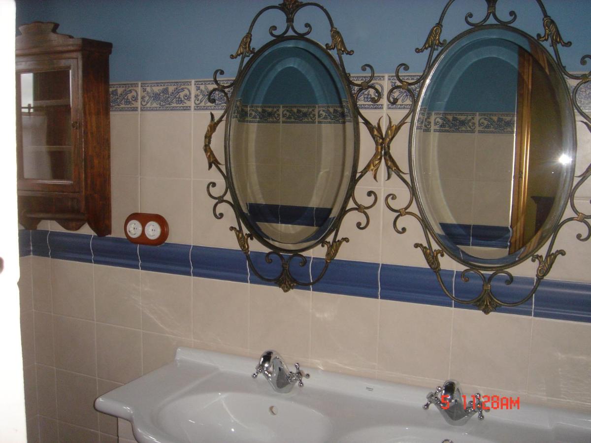 baño con 2 espejos y lavamanos en La Posada Del Canal, en Villanueva de San Mancio