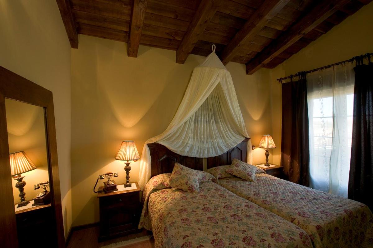 1 dormitorio con 1 cama con dosel y 2 lámparas en La Posada Del Canal, en Villanueva de San Mancio