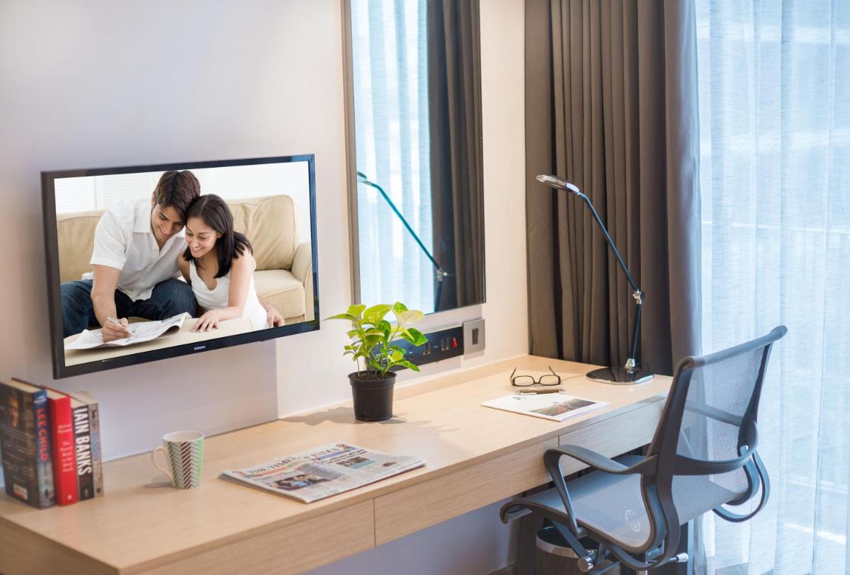 a tv on a wall in a living room at Citadines OMR Chennai in Chennai a tv on a wall in a living room at Citadines OMR Chennai in Chennai