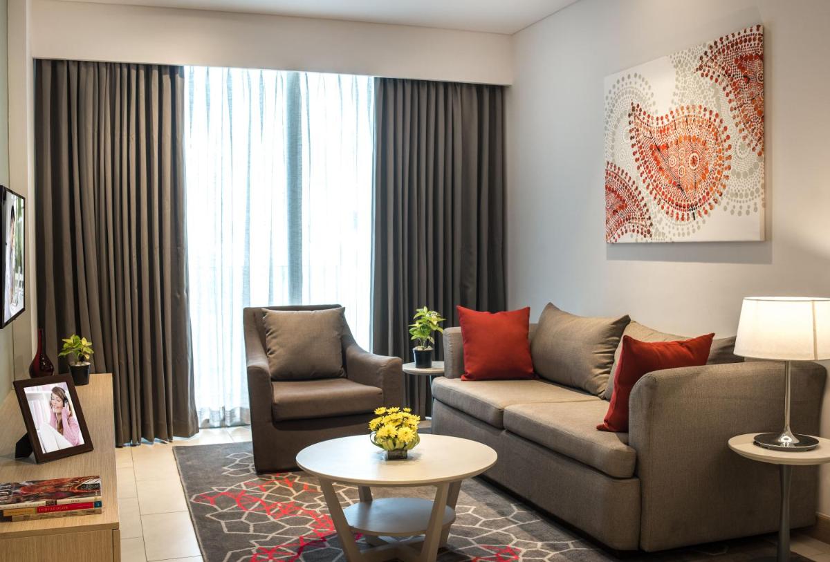 a living room with a couch and chairs and a table at Citadines OMR Chennai in Chennai a living room with a couch and chairs and a table at Citadines OMR Chennai in Chennai