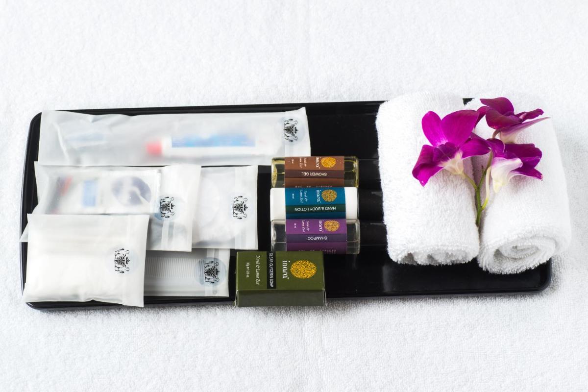 a tray with towels and a purple flower and cosmetics at Citadines OMR Chennai in Chennai a tray with towels and a purple flower and cosmetics at Citadines OMR Chennai in Chennai