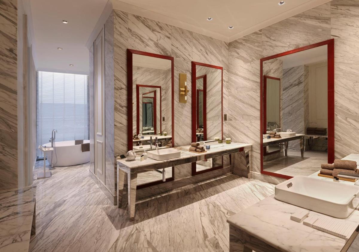 a bathroom with two sinks and a tub and mirrors at Roseate House New Delhi in New Delhi a bathroom with two sinks and a tub and mirrors at Roseate House New Delhi in New Delhi