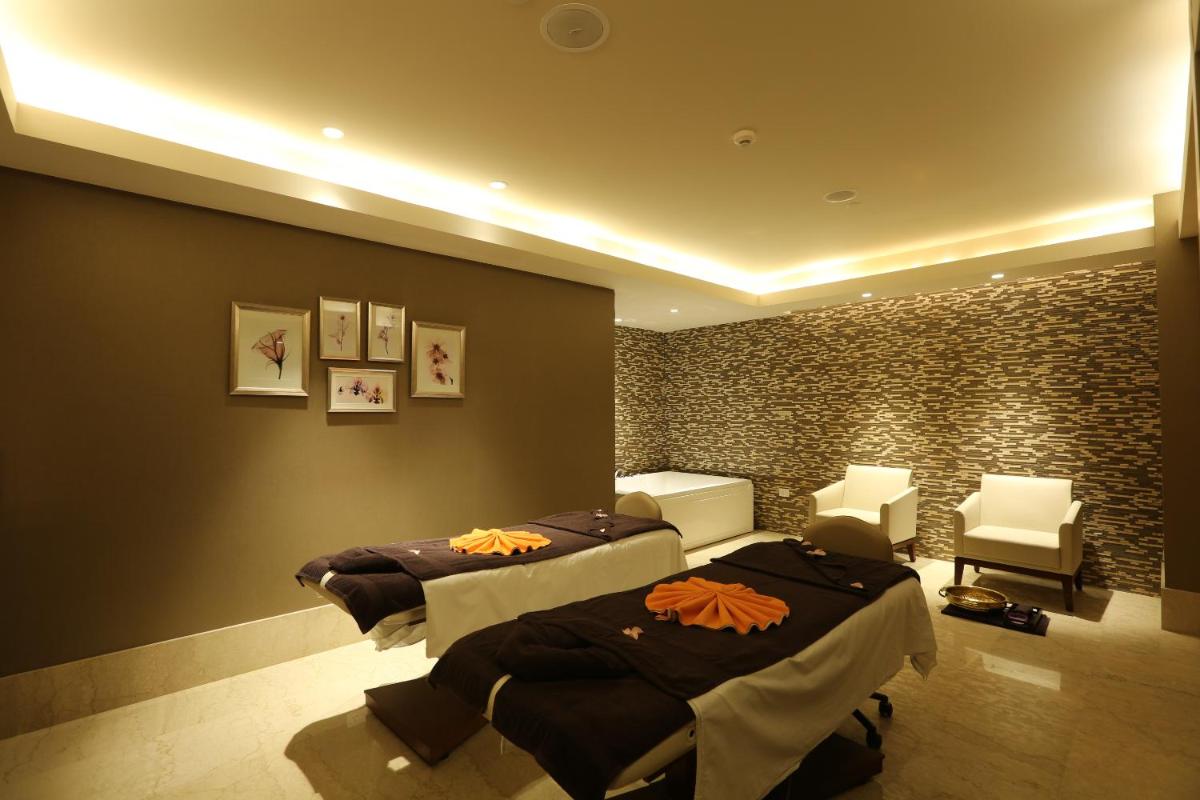 a hotel room with two beds and two chairs at Feathers- A Radha Hotel, Chennai in Chennai
